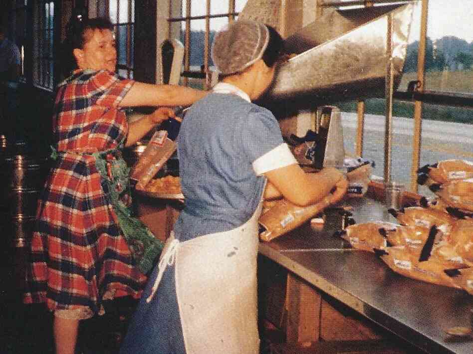 Mim Herr (right), with Mary Wowrer, packing chips by hand. Mim Herr (right), with Mary Wowrer, packing chips by hand.