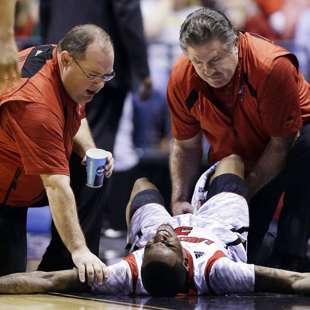 Trainers check on Louisville guard Kevin Ware after he injured his lower right leg during the Midwest Regional final against Duke in the NCAA college basketball tournament.