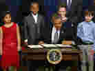 President Obama signs a series of executive orders on gun control Jan. 16 surrounded by children who wrote letters to the White House about gun violence. They are, from left, Hinna Zeejah, Taejah Goode, Julia Stokes and Grant Fritz.