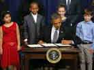 President Obama signs a series of executive orders on gun control Jan. 16 surrounded by children who wrote letters to the White House about gun violence. They are, from left, Hinna Zeejah, Taejah Goode, Julia Stokes and Grant Fritz.