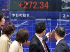 Passersby watch share prices spike in Tokyo on April 4, the day Japan's central bank announced a massive purchase of government bonds. The bank hopes the scale of the effort will boost Japan's slow-moving economy. Passersby watch share prices spike in Tokyo on April 4, the day Japan's central bank announced a massive purchase of government bonds. The bank hopes the scale of the effort will boost Japan's slow-moving economy.