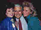 Joan Collins, John Forsythe and Linda Evans at a party celebrating the production of 150 episodes of Dynasty in 1986.