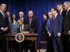 Vice President Biden and members of Congress watch as President Obama signs the STOCK Act on April 4, 2012. A year later, Congress moved to undo large portions of the law without fanfare.