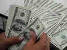 An employee at a money changer counts $100 bills in Manila on October 25, 2012.