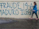 A woman walks past a message painted on a wall in the streets of Caracas reading "Fraud. Maduro Illegitimate." A woman walks past a message painted on a wall in the streets of Caracas reading "Fraud. Maduro Illegitimate."