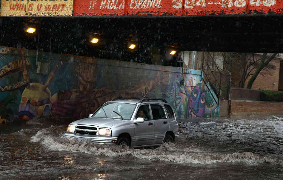 A motorist drives through standing water in a flooded underpass on Thursday in Chicago, Illinois. A motorist drives through standing water in a flooded underpass on Thursday in Chicago, Illinois.