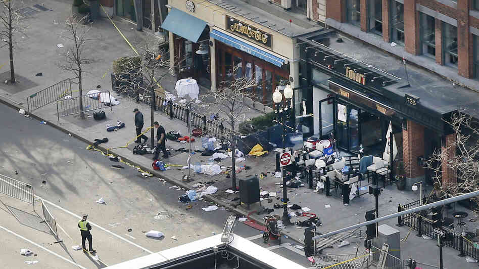 One of the blast sites on Boylston Street near the finish line of the Boston Marathon is investigated and guarded by police in the wake of Monday's attack. One of the blast sites on Boylston Street near the finish line of the Boston Marathon is investigated and guarded by police in the wake of Monday's attack.
