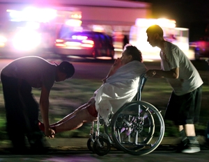 An injured person is assisted by two men as a nursing home is evacuated after the explosion.