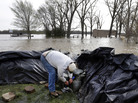 In Clarksville, Mo., Bob Bailey adjusts a pump as he tries to keep floodwater from the Mississippi River out of a rental property Sunday. The small community has worked for days to build a makeshift sandbag levee. In Clarksville, Mo., Bob Bailey adjusts a pump as he tries to keep floodwater from the Mississippi River out of a rental property Sunday. The small community has worked for days to build a makeshift sandbag levee.