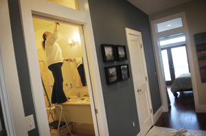 Amanda Cowley repaints her bathroom during renovations made to her new three-bedroom, two-bathroom townhouse.