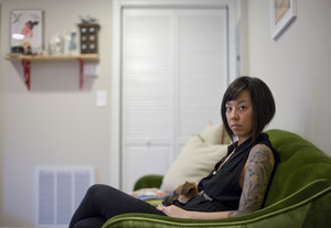 Graphic designer Kaleena Porter sits with her dog, Moby, in the living room of her new home in Northwest D.C.