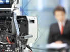 Newsreader in front of television camera. Newsreader in front of television camera.