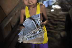 A boy shows the torn pages of a Quran at his home after sectarian violence spread through Zeegone, about 90 miles north of Yangon, in late March. More than 100 people were killed in similar incidents in the country's west last year.