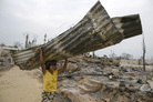 A Myanmarese girl carries away a tin roof in Meiktila, Myanmar. Violence between Buddhists and Muslims in March destroyed large areas of the town and left thousands of Muslims homeless. A Myanmarese girl carries away a tin roof in Meiktila, Myanmar. Violence between Buddhists and Muslims in March destroyed large areas of the town and left thousands of Muslims homeless.