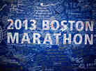 Signatures and messages adorn a Boston Marathon poster on Tuesday near the site of the April 15 bombings.