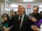 Sen. Max Baucus, D-Mont., is trailed by reporters Monday on Capitol Hill after announcing that he'll retire in 2014.