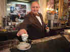 A barista serves coffee at a cafe in Naples, Italy. The Italian city's long-standing tradition of buying a cup for a less-fortunate stranger is now spreading across Europe.