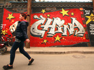 A woman in downtown Beijing walks past a building adorned with a patriotic mural by Chinese graffiti artists on April 22. A woman in downtown Beijing walks past a building adorned with a patriotic mural by Chinese graffiti artists on April 22.