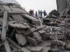 Bangladeshi rescue workers take a break Friday on the rubble of a building that collapsed Wednesday in Savar, near Dhaka, Bangladesh. By Friday, the death toll reached 300 as rescuers continued to search for injured and missing. Bangladeshi rescue workers take a break Friday on the rubble of a building that collapsed Wednesday in Savar, near Dhaka, Bangladesh. By Friday, the death toll reached 300 as rescuers continued to search for injured and missing.