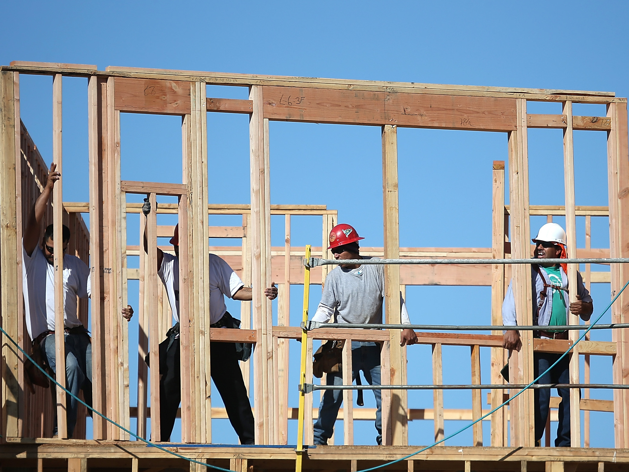 Construction workers move a framed wall into place at a new housing development in San Mateo, Calif. (Image credit: Getty Images)