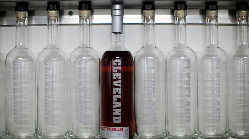 A bottle of Cleveland Whiskey's bourbon sits on a shelf with empty bottles at the company's distillery.