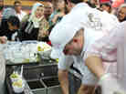 Employees scoop ice cream, which is topped with pistachios, at Bakdash's opening in Amman, Jordan, this week. Bakdash has been a landmark in Damascus, Syria, since 1895. But the war there has made it hard to get supplies, so the owners have set up a new shop in Amman.