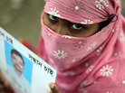 A Bangladeshi family member holds up the portrait of her missing relative, believed to be trapped in the rubble of the collapsed Rana Plaza. A Bangladeshi family member holds up the portrait of her missing relative, believed to be trapped in the rubble of the collapsed Rana Plaza.