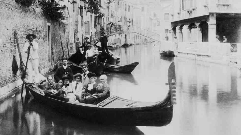 Gondolas have long played a part in the Venetian tourist experience. But as tourism has grown and the local population has declined, everyday gondolas called traghetti have all but disappeared. Above, a group of tourists poses on a canal, circa 1900. Gondolas have long played a part in the Venetian tourist experience. But as tourism has grown and the local population has declined, everyday gondolas called traghetti have all but disappeared. Above, a group of tourists poses on a canal, circa 1900.