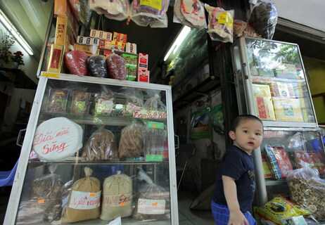 A young boy walks out of a traditional medicine shop in downtown Hanoi that sells grinding plates for rhino horns.