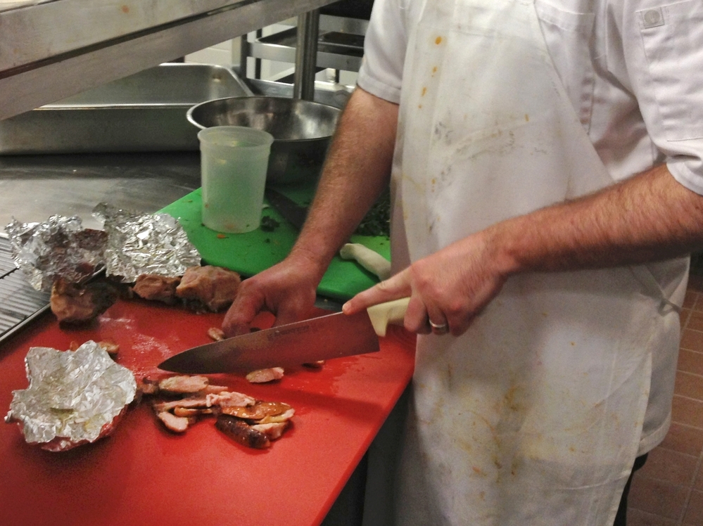 A chef in the kitchen of NPR headquarters prepares turkey tails.