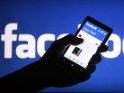 A smartphone user shows the Facebook application on his phone. A smartphone user shows the Facebook application on his phone.