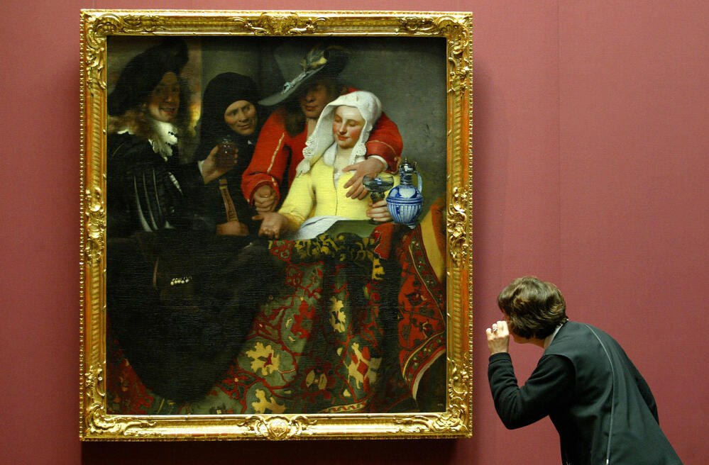 The Procuress, painted by Johannes Vermeer in 1656, hangs in a Dresden, Germany, museum in 2004. While this particular work is not in question, Benjamin Binstock argues that other pieces attributed to the Dutch master are by an apprentice and a member of his household.