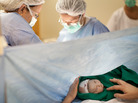 Daniele Coelho holds her newborn daughter as doctors finish her cesarean section at the Perinatal Clinic in Rio de Janeiro on Aug. 2. Brazil has one of the world's highest rates of cesarean births. Daniele Coelho holds her newborn daughter as doctors finish her cesarean section at the Perinatal Clinic in Rio de Janeiro on Aug. 2. Brazil has one of the world's highest rates of cesarean births.
