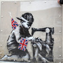 A man inspects a plastic cover placed over Slave Labour, an artwork attributed to Banksy, in London. This piece of art was put up for sale in Miami last February, but the ensuing outrage led to the auction's cancellation. The mural is now part of an exhibition in London, and is is expected to move to the U.S. afterward.