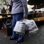 A woman who just bought toilet paper at a grocery store reads her receipt as she leaves the store in Caracas, Venezuela, on Wednesday. The government says it will import 50 million rolls of toilet paper amid a shortage.