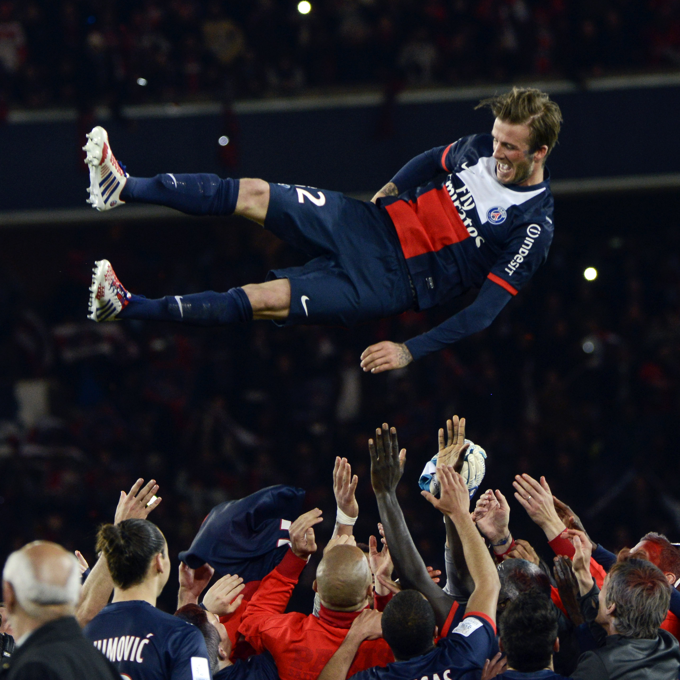 Paris Saint-Germain's English midfielder David Beckham is thrown in the air by teammates after a French L1 football match between Paris St Germain and Brest on Saturday at Parc des Princes stadium in Paris.