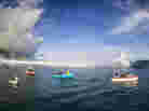 Boats line up to photograph this year's Teahupoo swell in Tahiti.