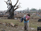 A woman carries her child through a field near the collapsed Plaza Towers Elementary School in Moore, Okla., on Monday A tornado as much as a mile wide with winds up to 200 mph roared through the Oklahoma City suburbs flattening entire neighborhoods, setting buildings on fire and landing a direct blow on an elementary school. A woman carries her child through a field near the collapsed Plaza Towers Elementary School in Moore, Okla., on Monday A tornado as much as a mile wide with winds up to 200 mph roared through the Oklahoma City suburbs flattening entire neighborhoods, setting buildings on fire and landing a direct blow on an elementary school.