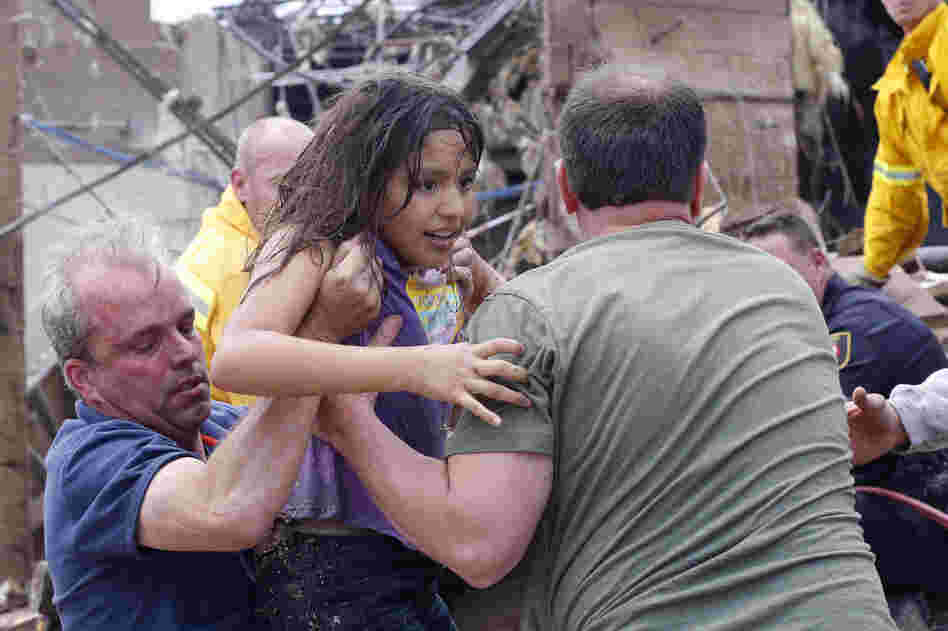 A child is pulled from the rubble of Plaza Towers Elementary School in Moore, Okla., on Monday, after a tornado as much as a mile wide with winds up to 200 mph roared through the Oklahoma City suburbs.