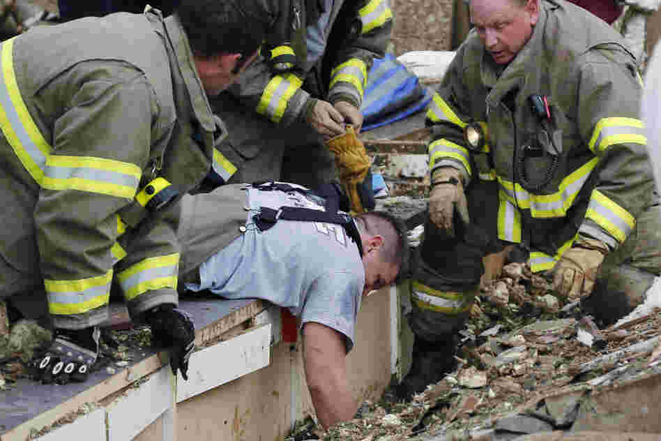 Rescue workers dig through the rubble of a collapsed wall at Plaza Tower Elementary School to free trapped students.