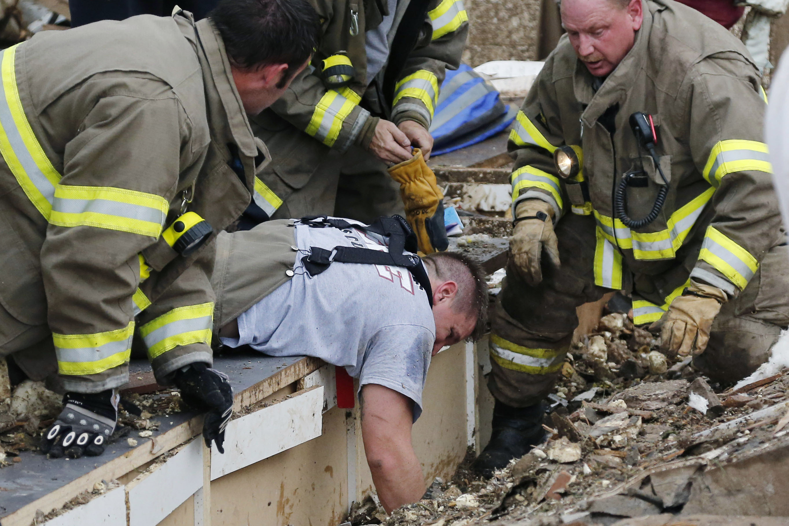 Rescue workers dig through the rubble of a collapsed wall at Plaza Tower Elementary School to free trapped students.