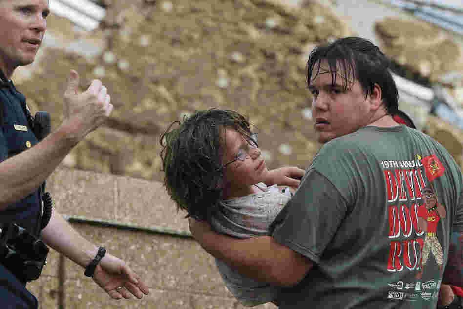 A child is carried from the rubble of Plaza Towers Elementary School.