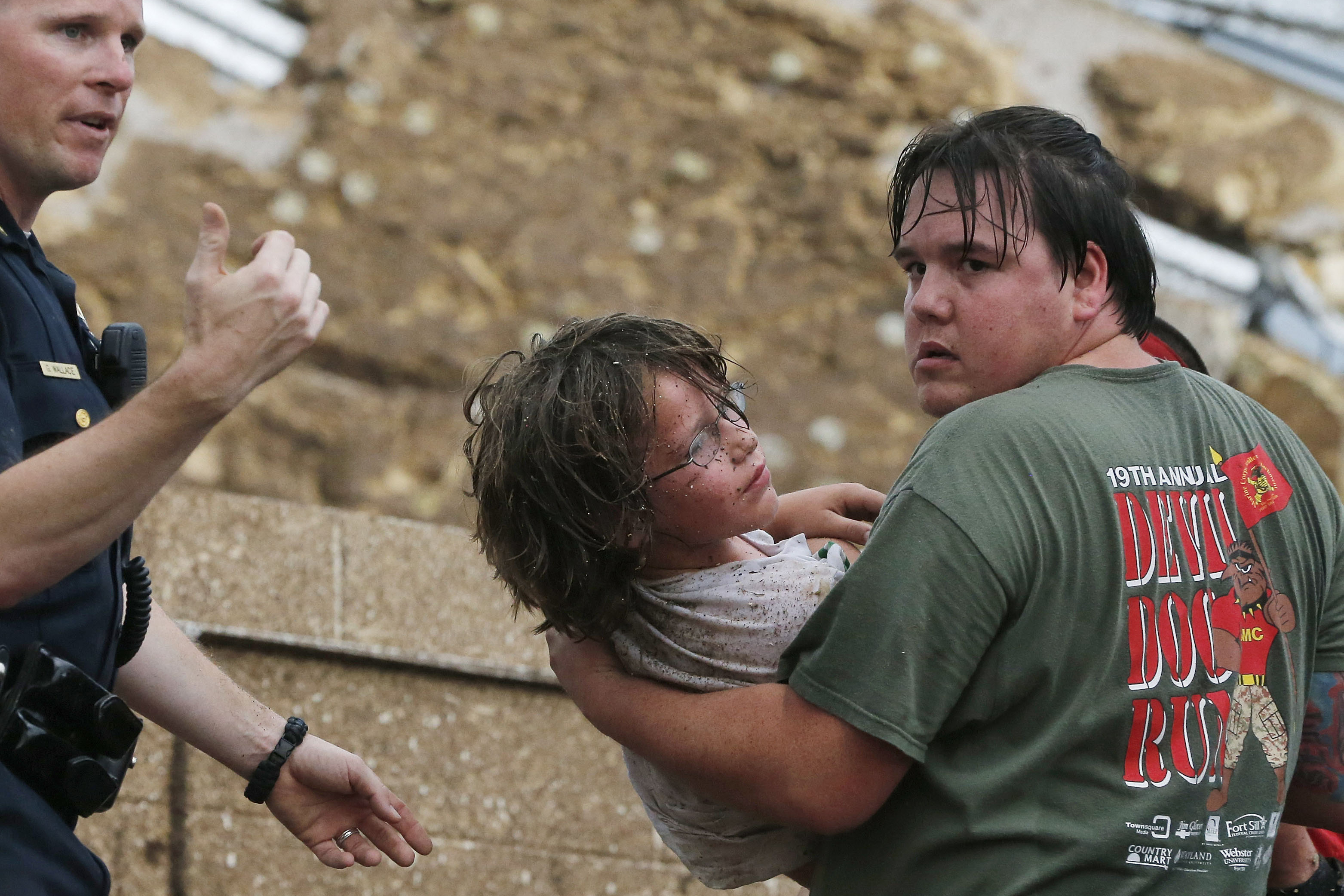A child is carried from the rubble of Plaza Towers Elementary School.