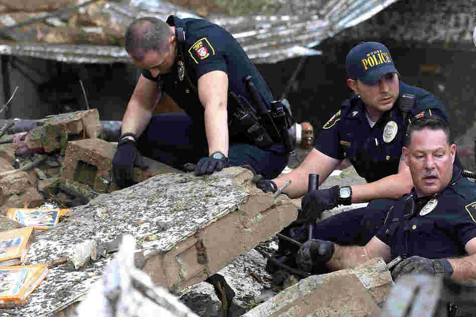 Moore police dig through the rubble of the Plaza Towers Elementary School.
