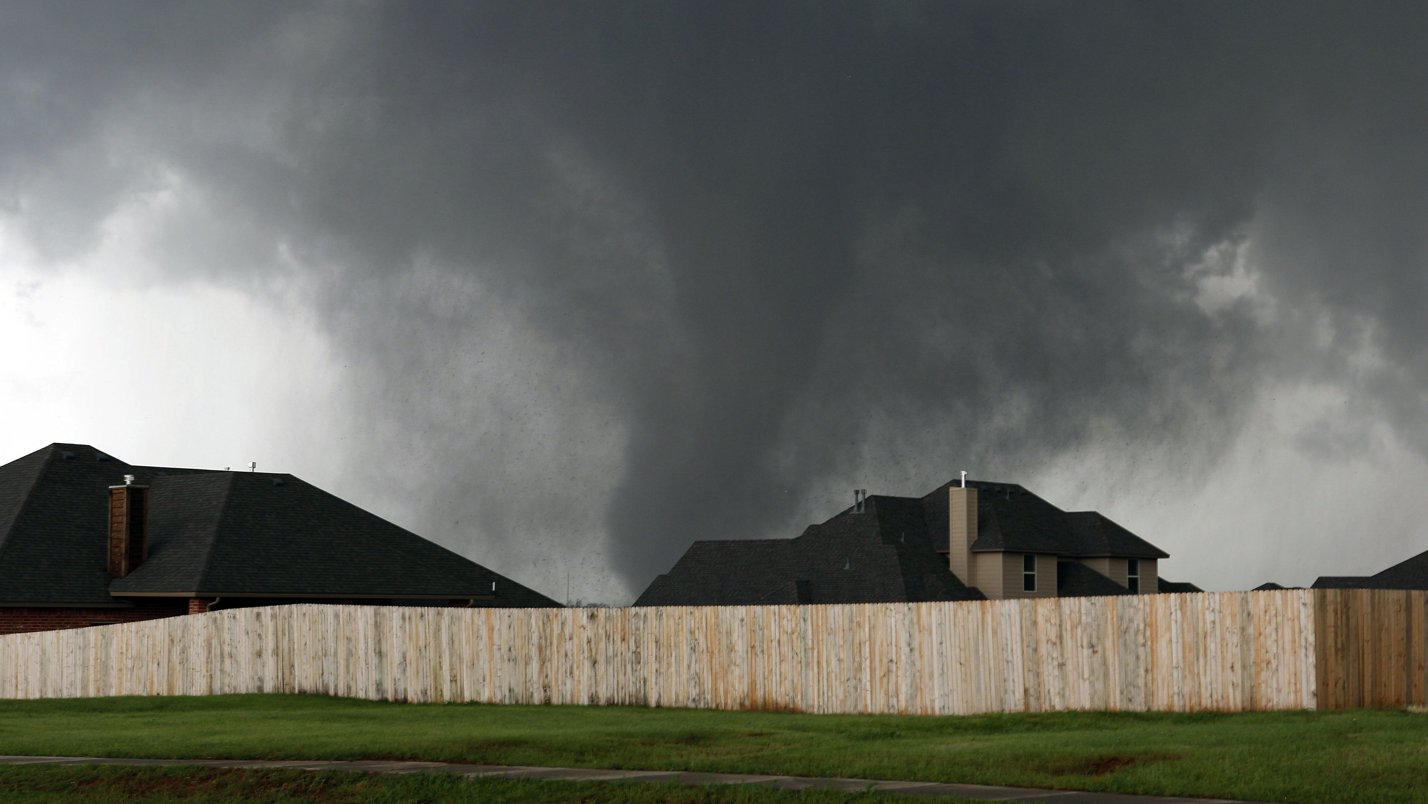 A tornado moves past homes in Moore, Okla. on Monday.