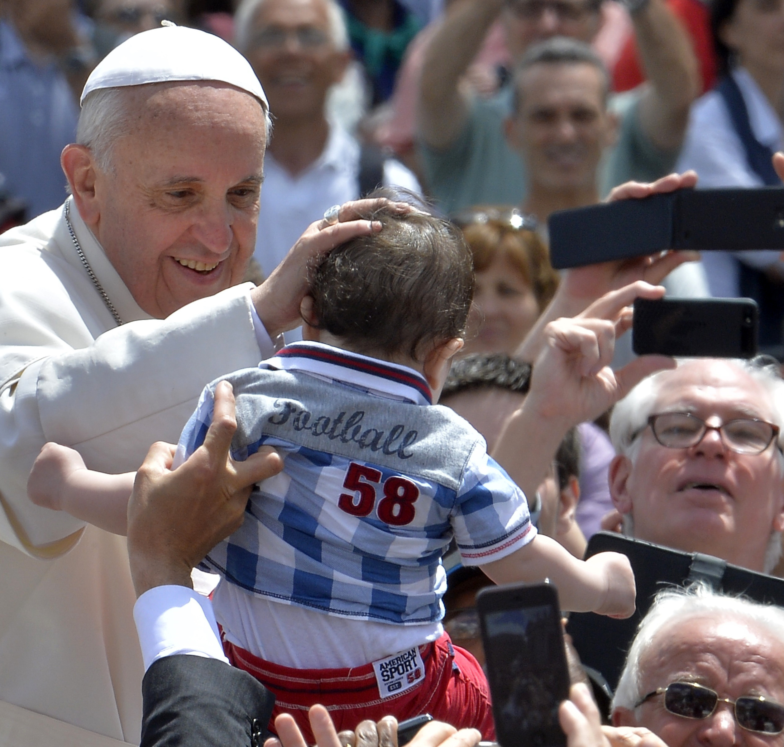 Pope Francis blesses a child as he leaves in his popemobile after the Holy Mass, May 19, at St. Peter's Square at the Vatican.