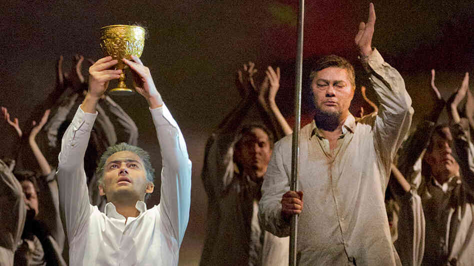 Parsifal (Jonas Kaufmann) lifts the Holy Grail as Gurnemanz (Rene Pape) looks on, in a recent Metropolitan Opera production of Wagner's final opera, Parsifal. Parsifal (Jonas Kaufmann) lifts the Holy Grail as Gurnemanz (Rene Pape) looks on, in a recent Metropolitan Opera production of Wagner's final opera, Parsifal.
