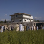 Pakistanis, along with international and local media, gather outside Osama bin Laden's compound, a day after the successful raid by U.S. Special Forces in May 2011.