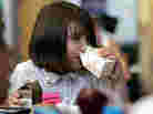Morgan Barnett, 7, drinks from containers of 1 percent milk and chocolate milk during lunch at a school in St. Paul, Minn., in 2006.