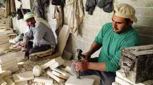 A worker chips away at Jerusalem stone, likely destined for a building facade somewhere in the world. Stone and marble is a big business in Palestinian towns near Bethlehem. Quarries are in Israeli-controlled areas, and access can be a challenge.